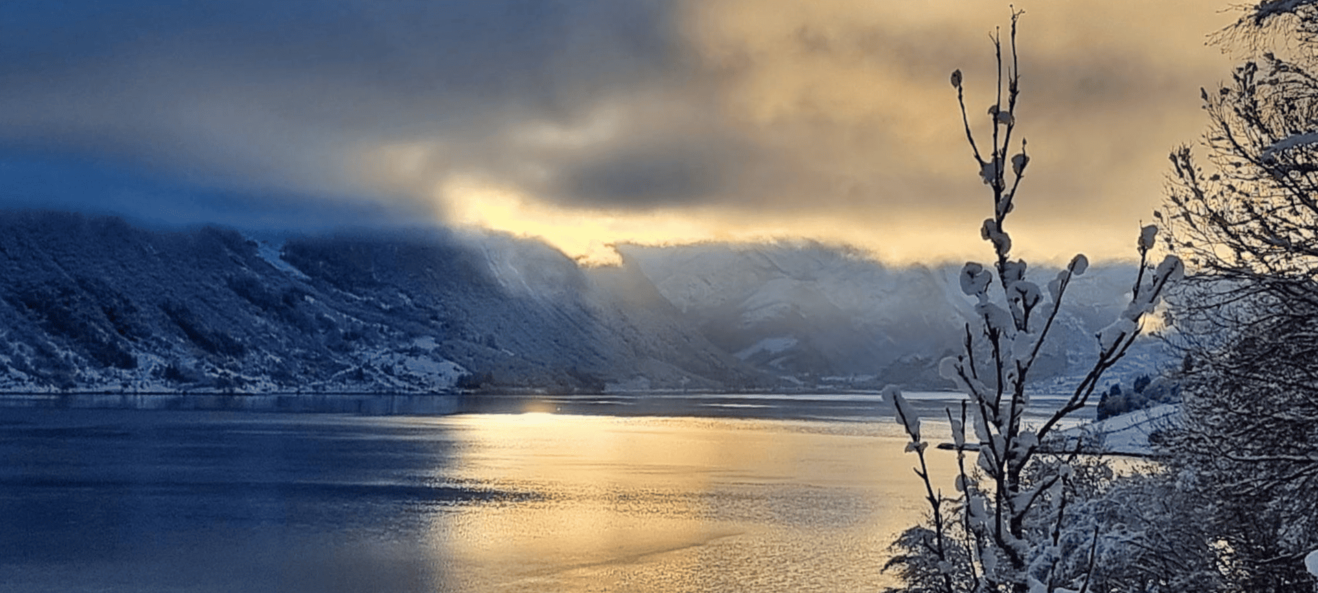 Vinterlig utsikt over fjorden med snødekte fjellsider