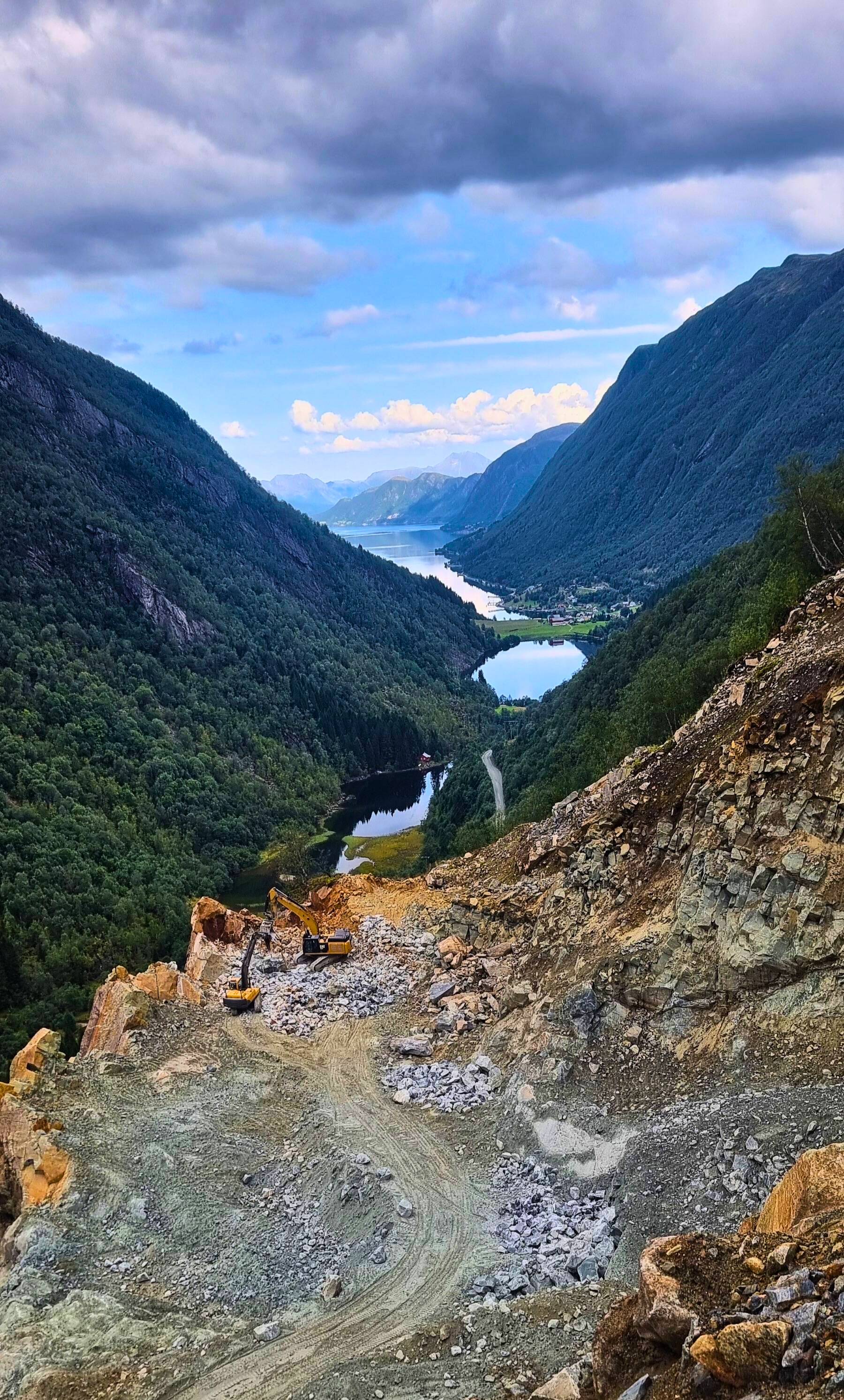 Steinsvik dal med utsikt over fjorden, man ser dagruddet med to gravimaskin som graver 