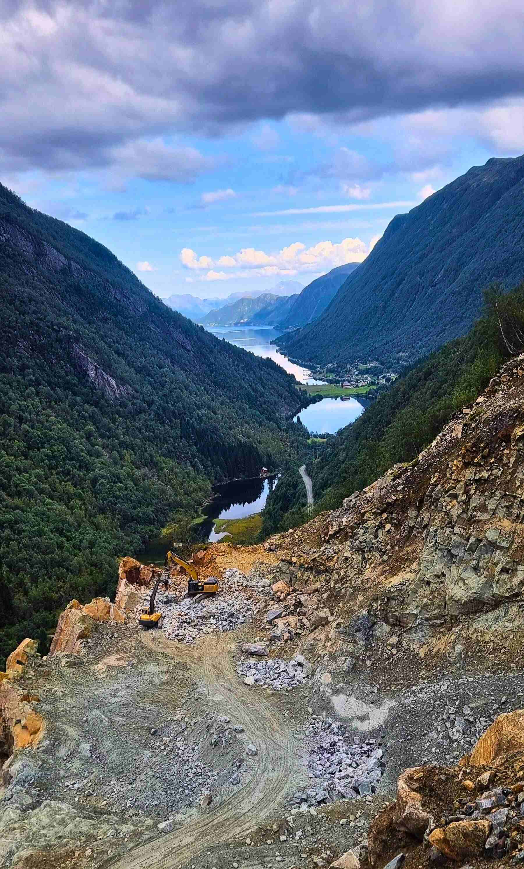 Steinsvik dal med utsikt over fjorden, man ser dagruddet med to gravimaskin som graver 